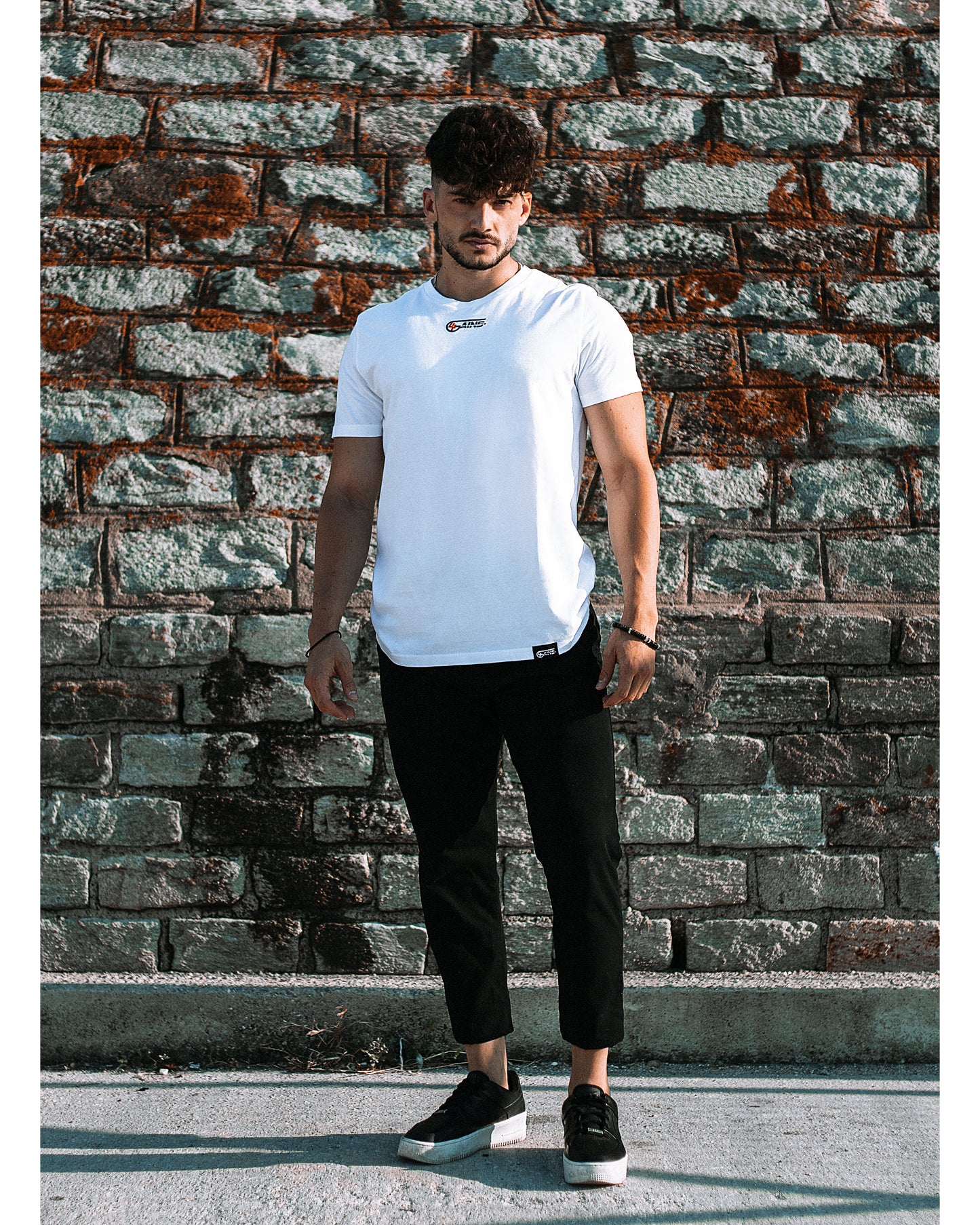 Model trägt 4GAINS unisex T-Shirt in white/black/orange