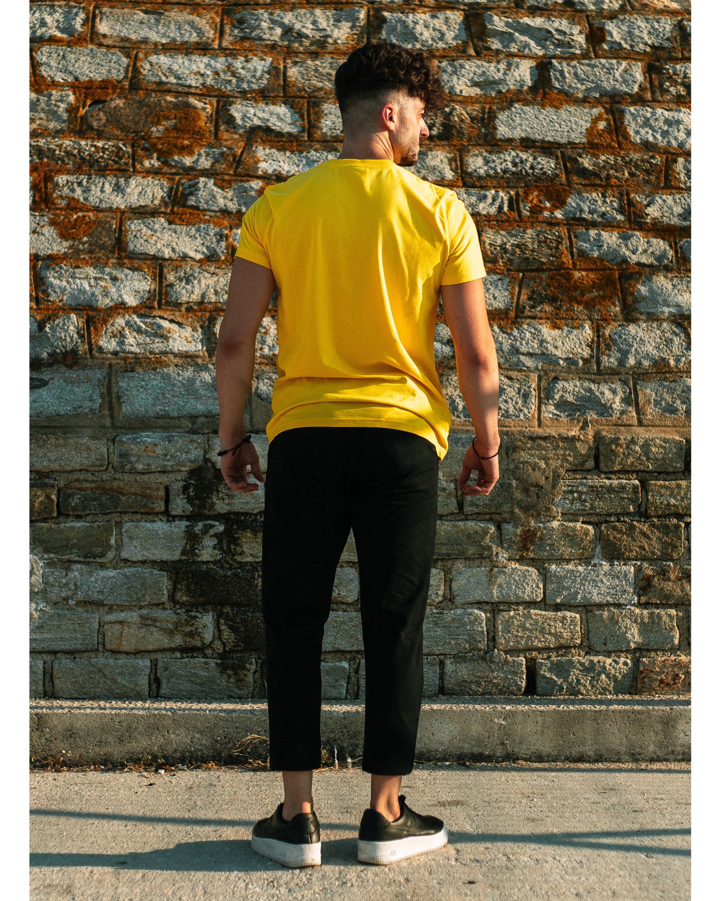 Model wears 4GAINS unisex t-shirt in yellow/black