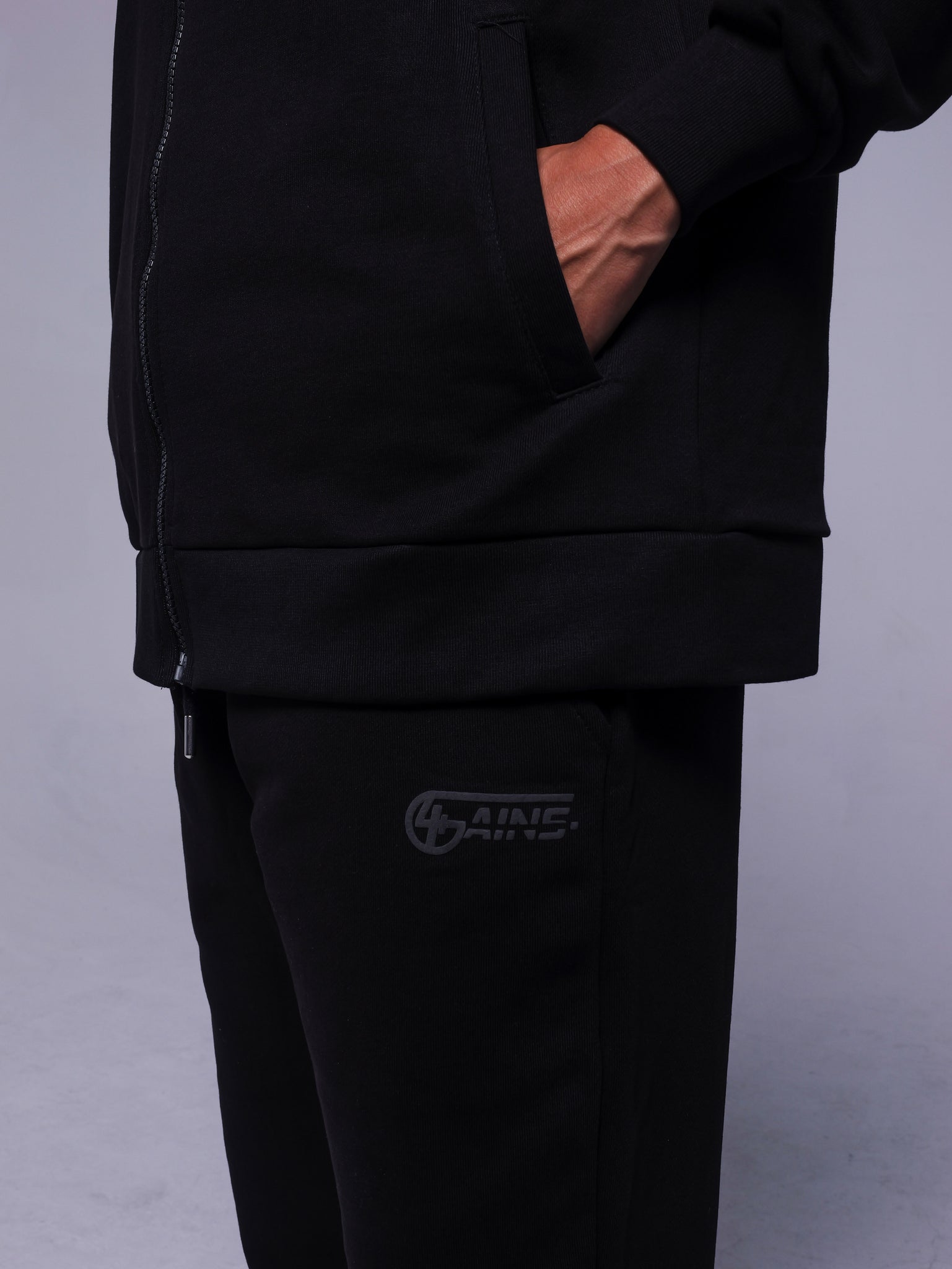 4GAINS Tracksuit Hose in der Farbe schwarz mit schwarzem Puff Print an einem Model