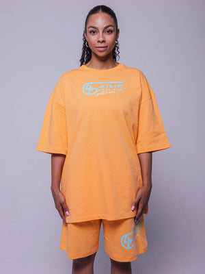 4GAINS Sportswear oversized T-shirt in der Farbe apricot mit türkisenem Aufdruck an einem weiblichen Model