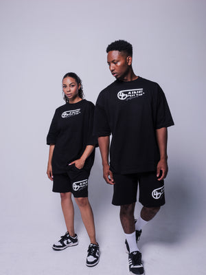 4GAINS Sportswear oversized T-shirt in der Farbe schwarz mit weißem Aufdruck an einem weiblichen und männlichen Model stehend