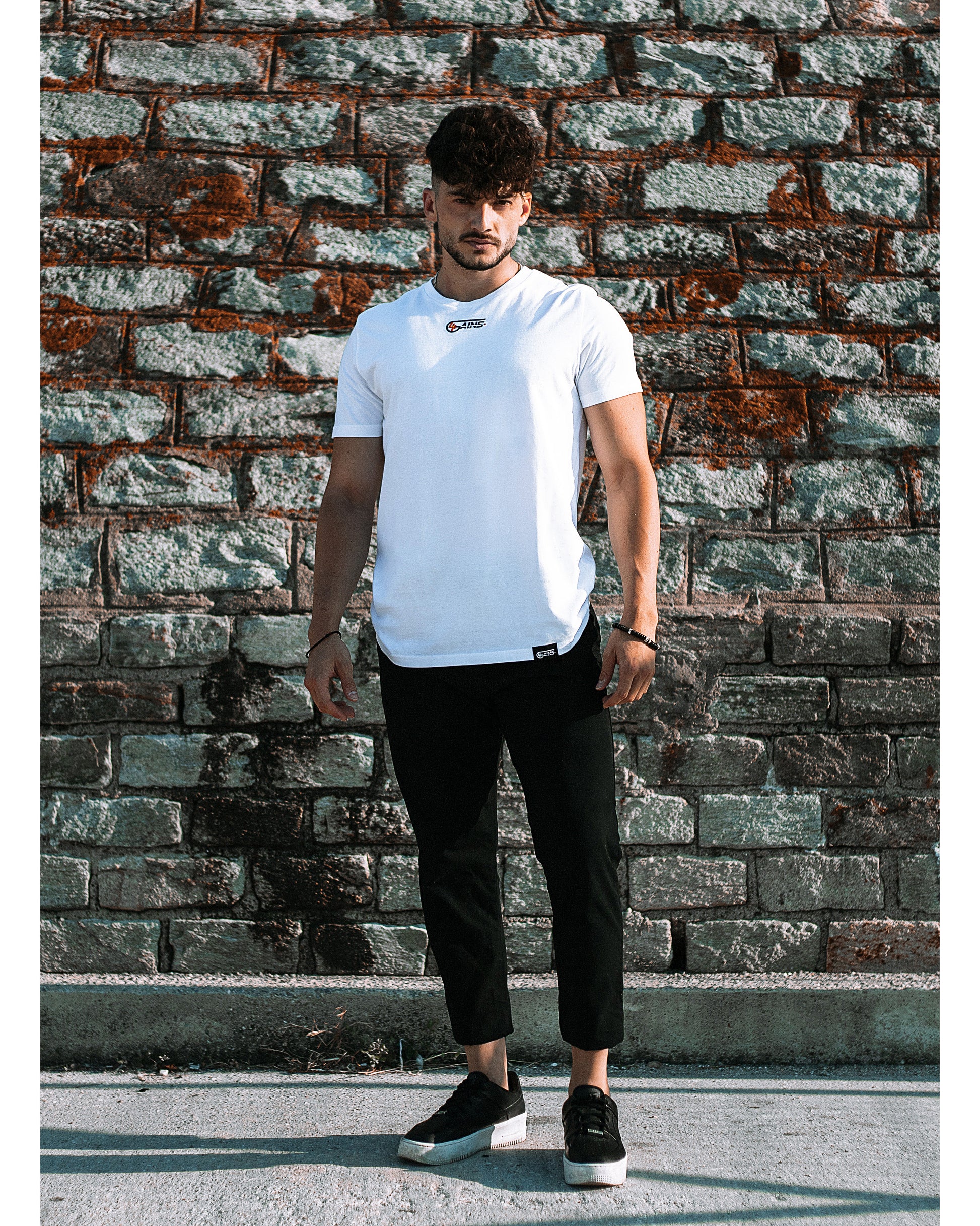 Model trägt 4GAINS unisex T-Shirt in white/black/orange