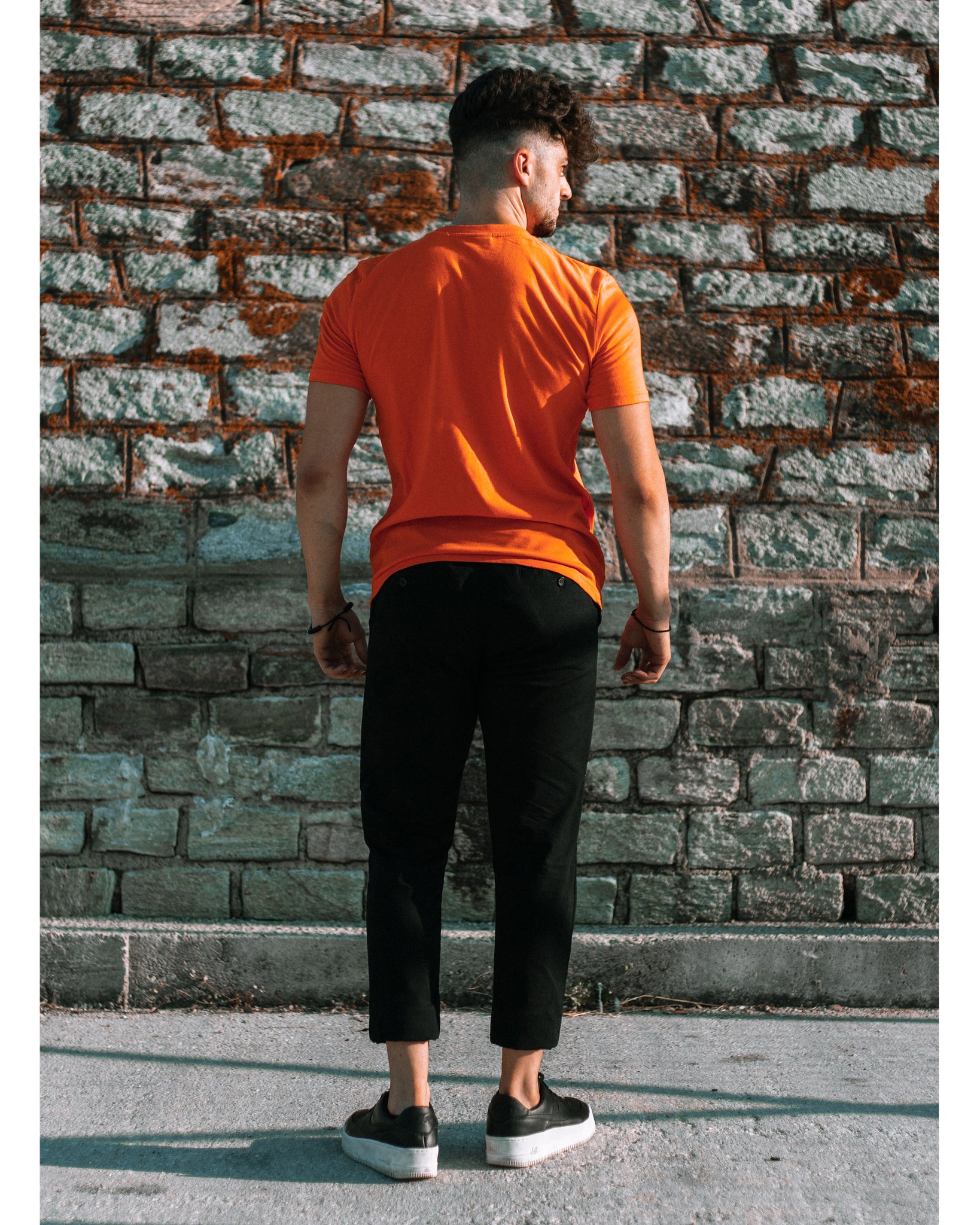 Model trägt 4GAINS unisex T-Shirt in orange/black