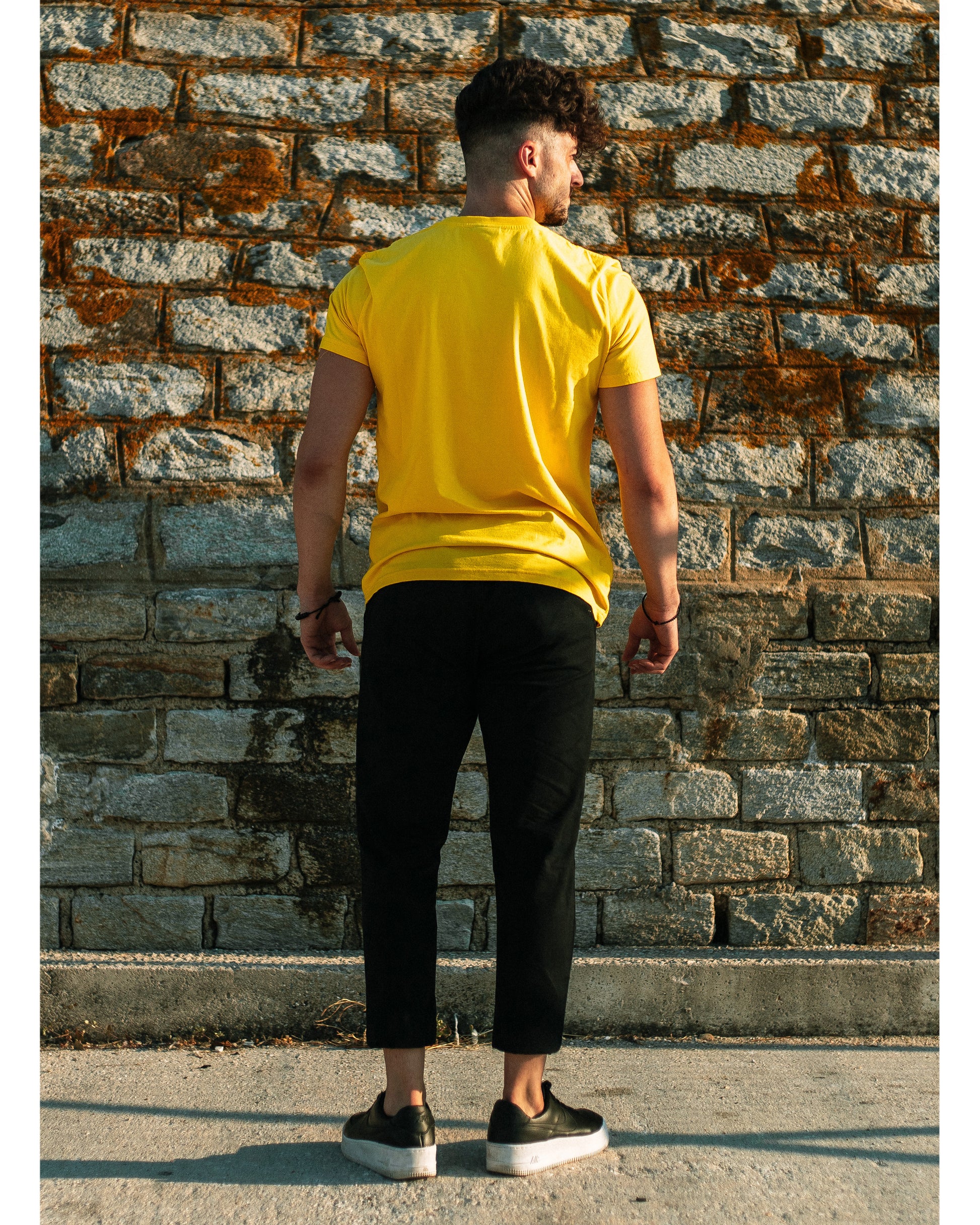 Model wears 4GAINS unisex t-shirt in yellow/black