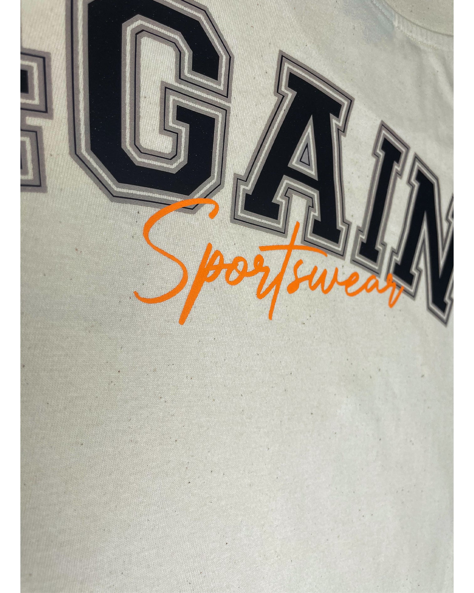 Detail Aufnahme vom orangenen "Sportswear" Schriftzug auf der Rückseite des T-Shirts