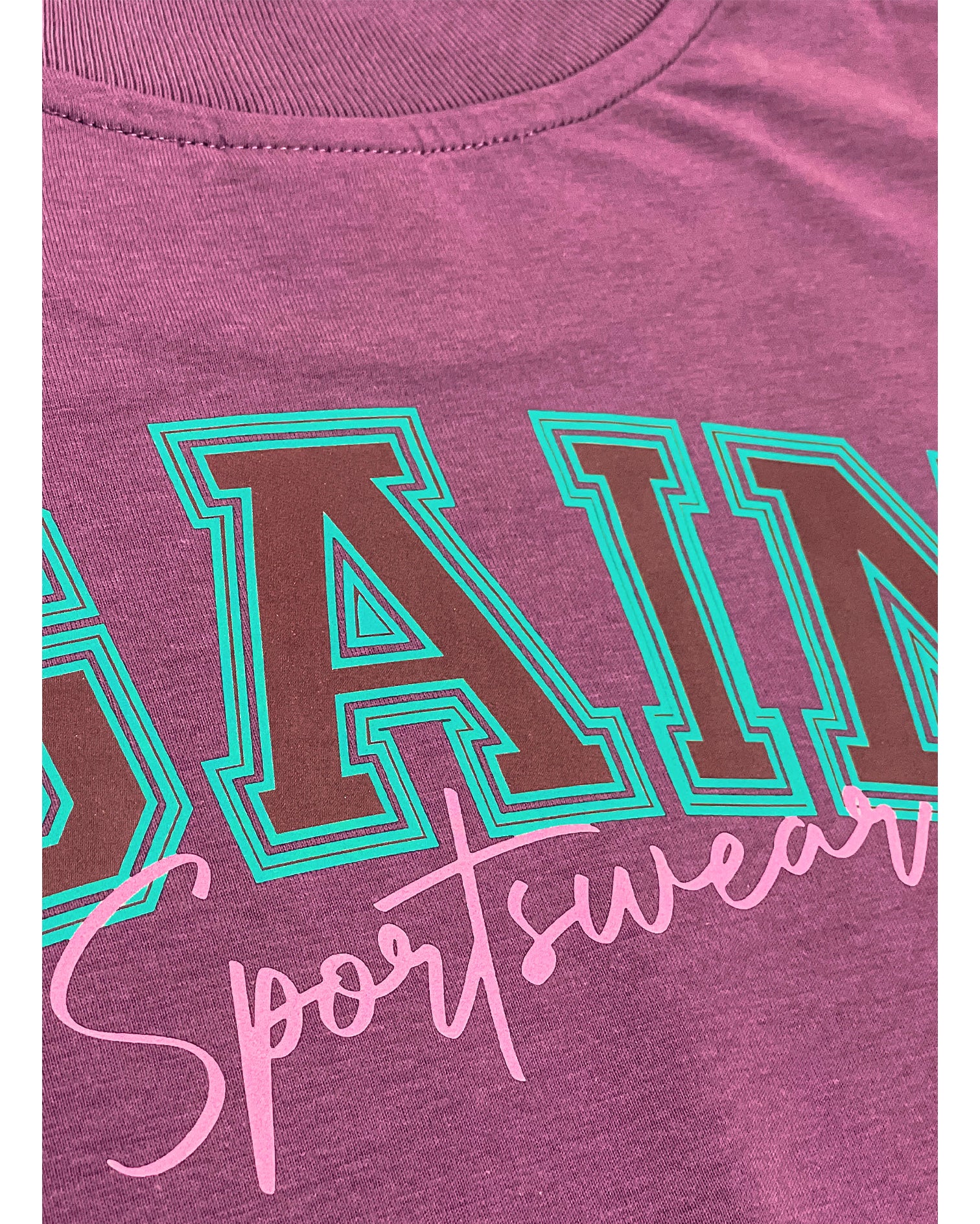Detail Aufnahme vom rosanem "Sportswear" Schriftzug auf der Rückseite des T-Shirts